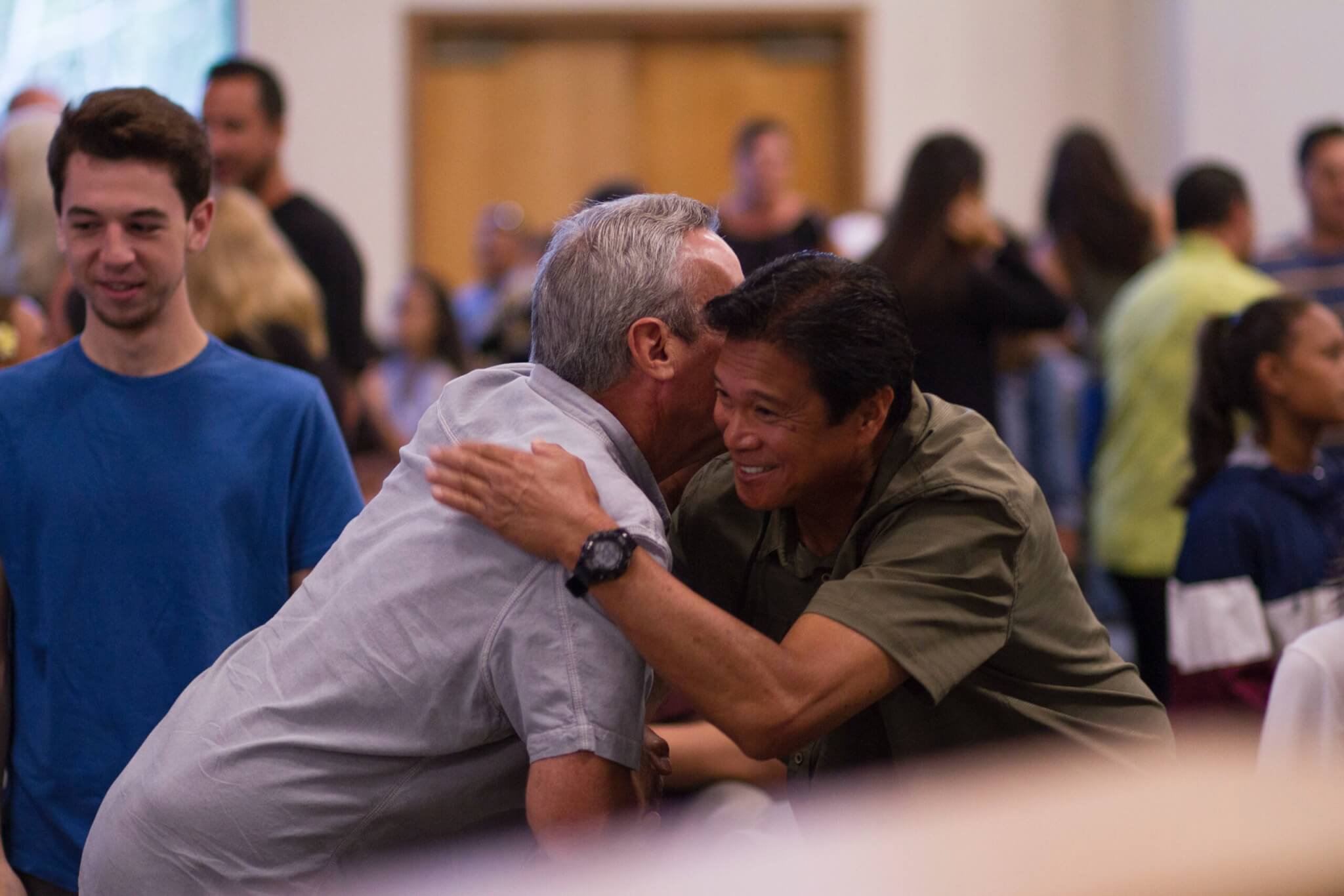 two people hugging in a crowded room