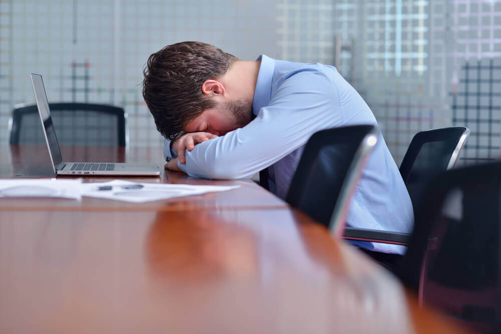 Young businessman with problems and stress in the office
