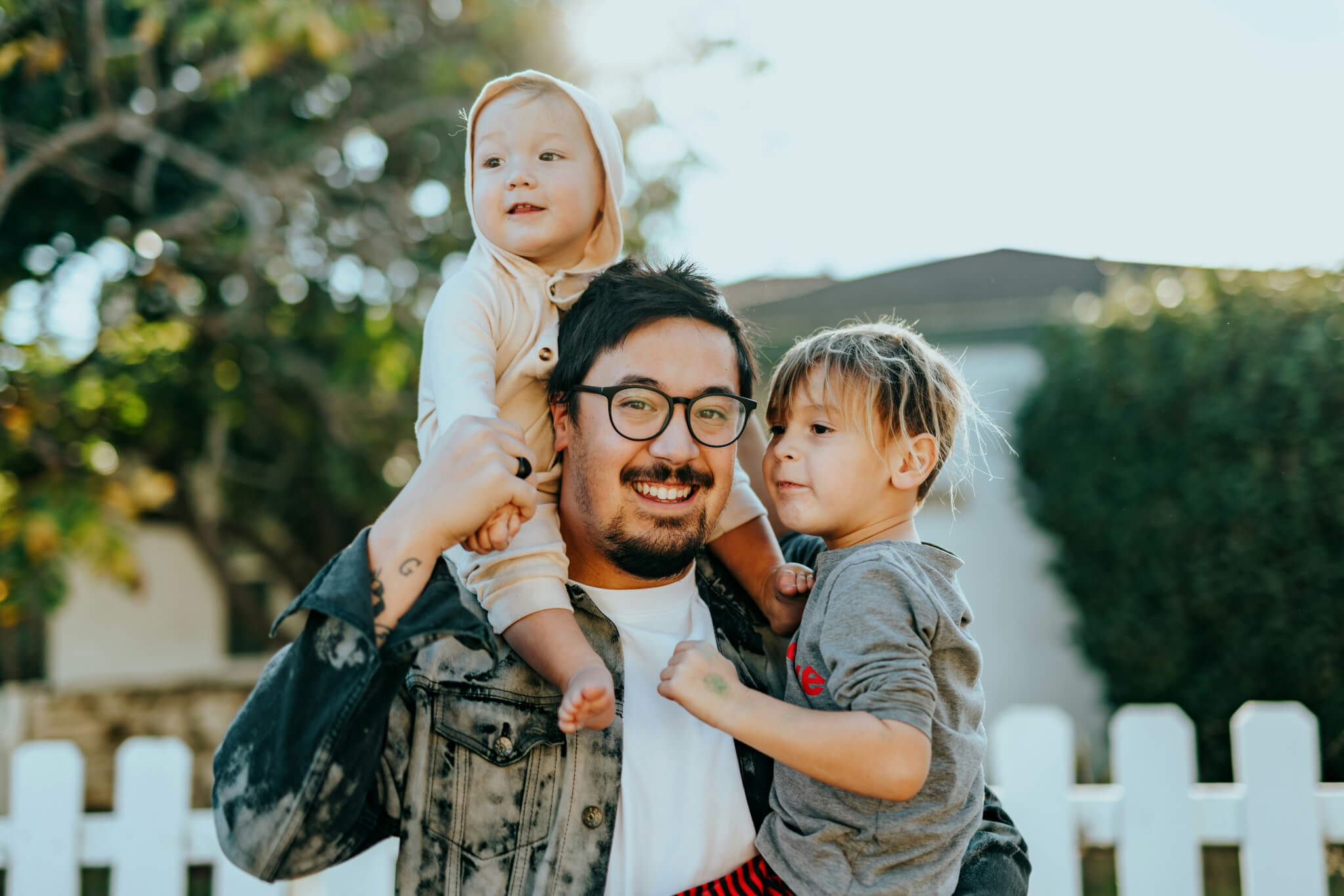 a father holding two young kids