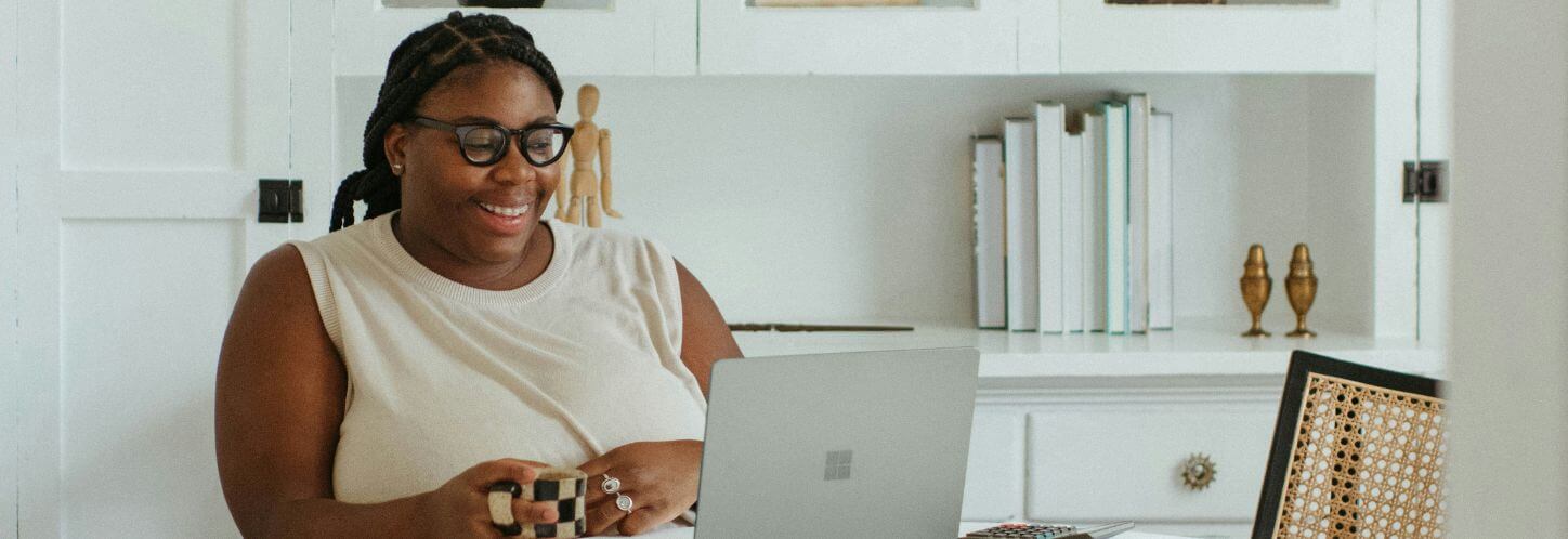 An employee smiles at their laptop