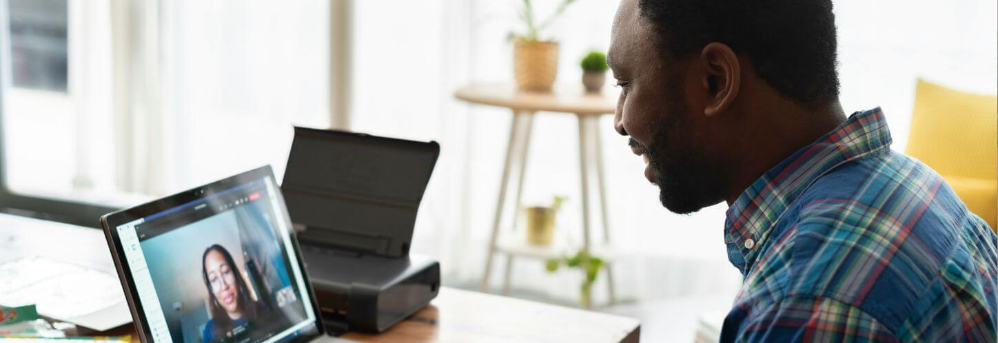 A new employee speaks with their colleague via laptop