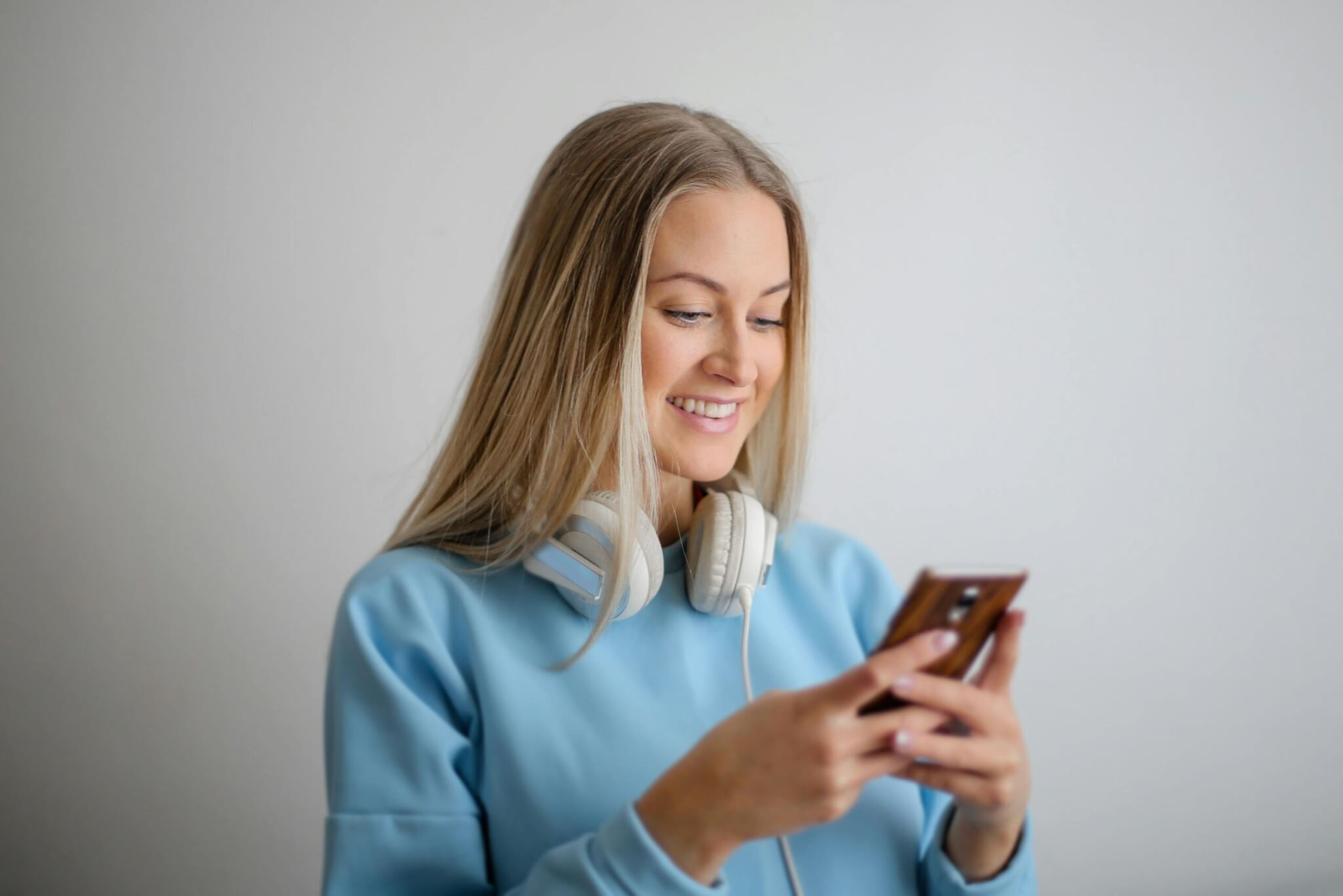 A woman looks at her phone and smiles