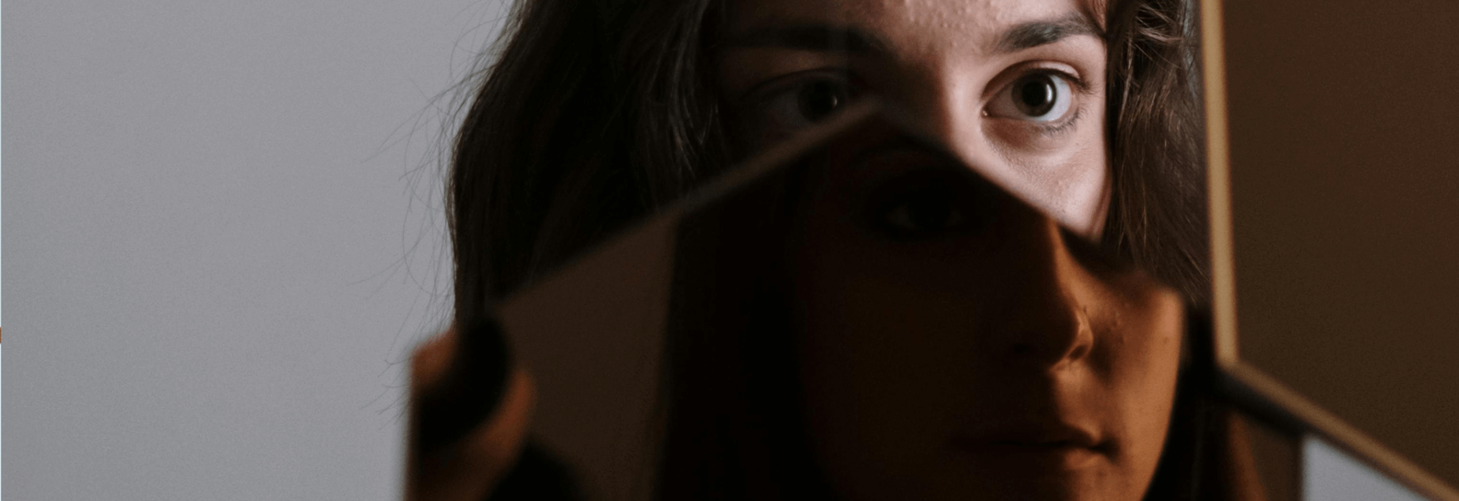 image of a woman holding a mirror